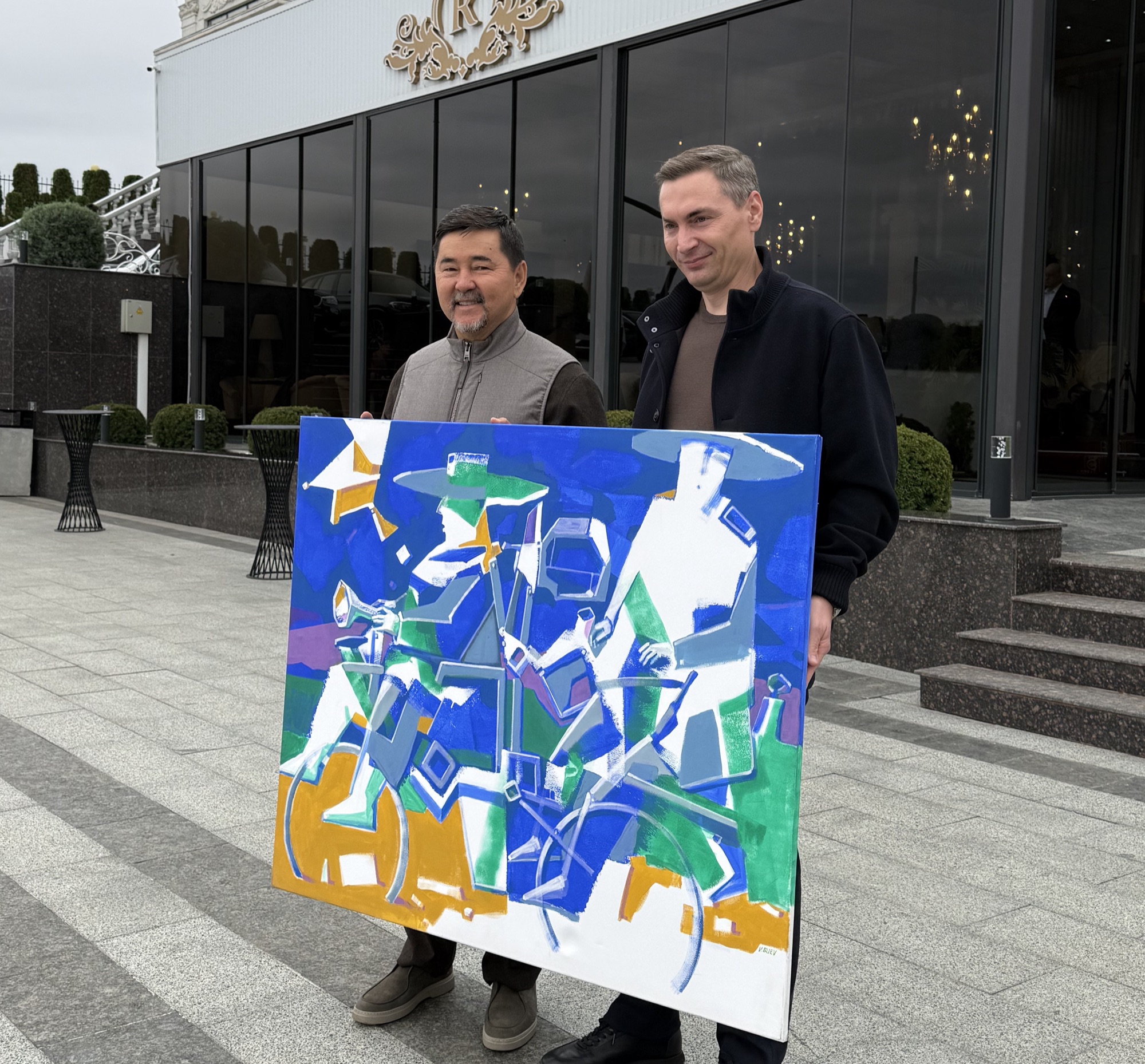Margulan Seissembayev alături de pictura „The Wandering Poets” de BUEV